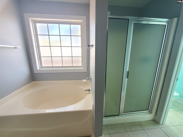 bathroom featuring toilet, independent shower and bath, and tile patterned flooring