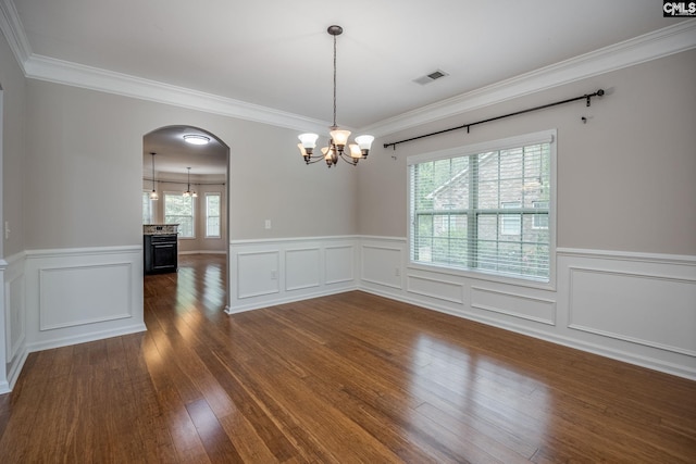 empty room with ornamental molding, a chandelier, and dark hardwood / wood-style flooring