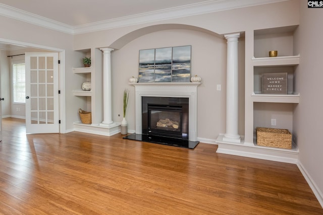 unfurnished living room with crown molding, hardwood / wood-style flooring, built in shelves, and ornate columns