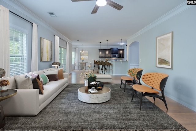 living room with ceiling fan, ornamental molding, and dark hardwood / wood-style floors