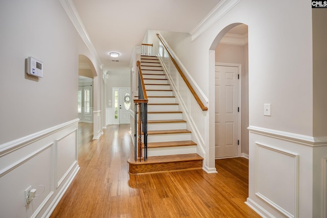 stairs featuring hardwood / wood-style flooring and ornamental molding