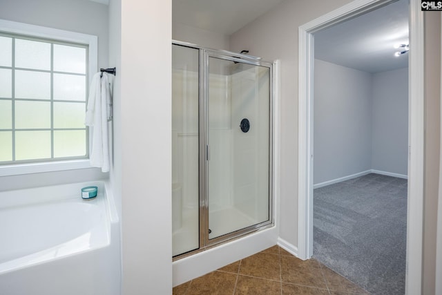 bathroom with independent shower and bath, a healthy amount of sunlight, and tile patterned floors