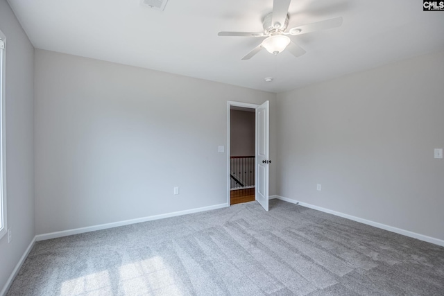 carpeted spare room with ceiling fan