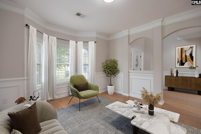 sitting room with ornamental molding and light hardwood / wood-style flooring