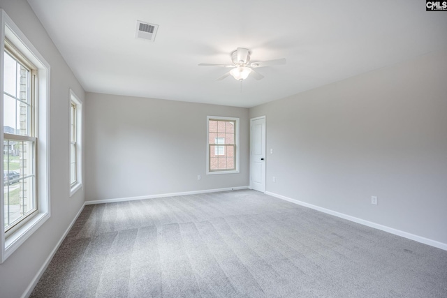 carpeted spare room with ceiling fan