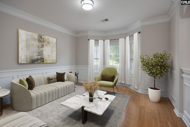 living area with crown molding and light hardwood / wood-style flooring