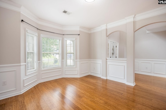 empty room featuring crown molding and light wood-type flooring