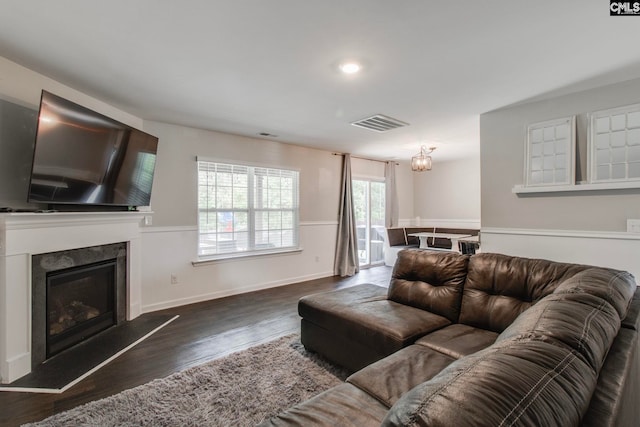 living room featuring dark wood-type flooring and a high end fireplace