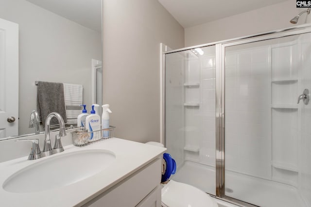 bathroom with walk in shower, vanity, and toilet