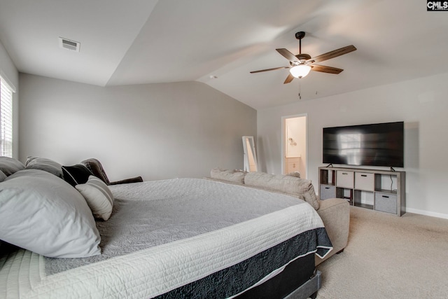 bedroom with vaulted ceiling, carpet flooring, ceiling fan, and ensuite bath