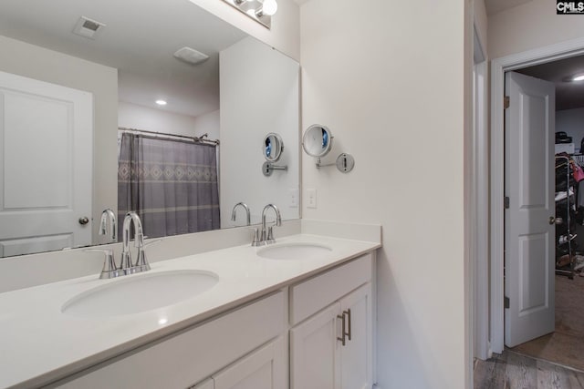 bathroom with vanity, hardwood / wood-style flooring, and walk in shower