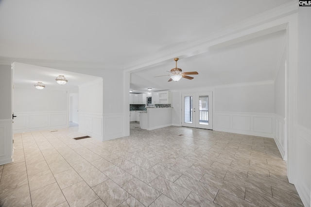 unfurnished living room with ornamental molding, ceiling fan, and french doors