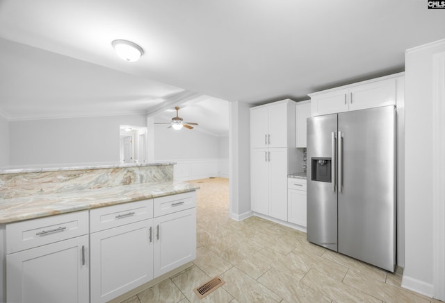 kitchen featuring lofted ceiling, white cabinets, ceiling fan, stainless steel refrigerator with ice dispenser, and light stone countertops