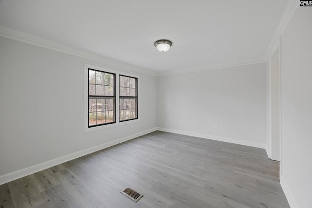 unfurnished room with ornamental molding and light wood-type flooring