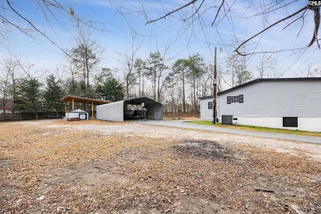 view of yard with a carport, central air condition unit, and a storage unit