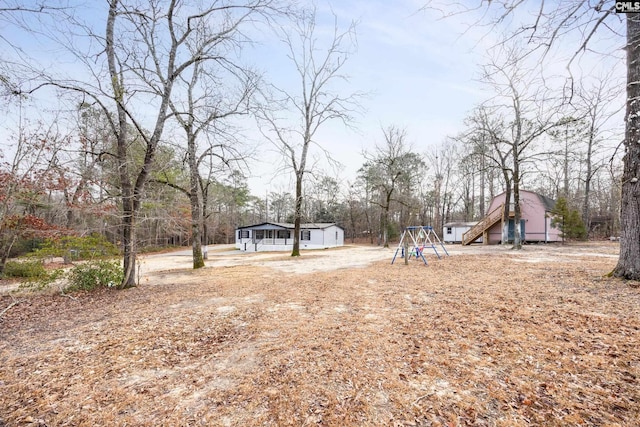 view of yard with a storage shed and a playground