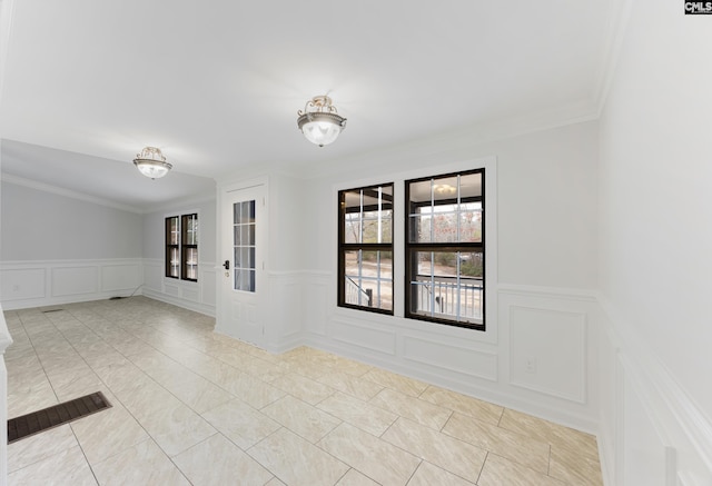 tiled empty room featuring crown molding