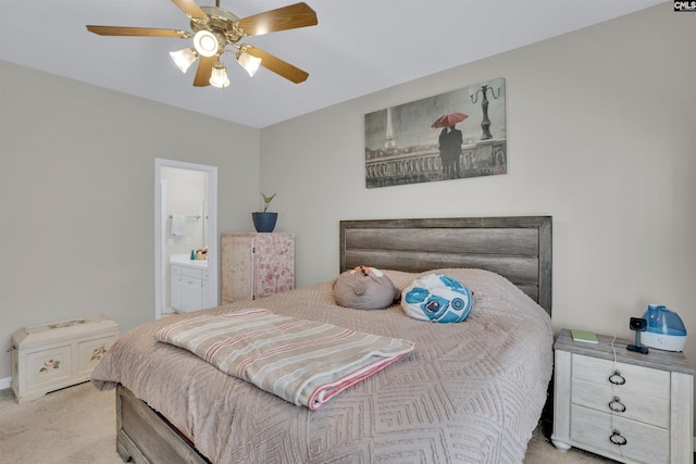 carpeted bedroom with ensuite bath and ceiling fan