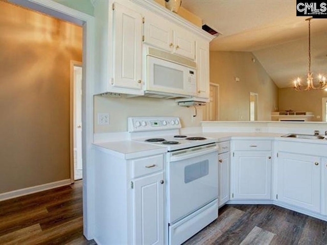 kitchen with white appliances, hanging light fixtures, and white cabinets