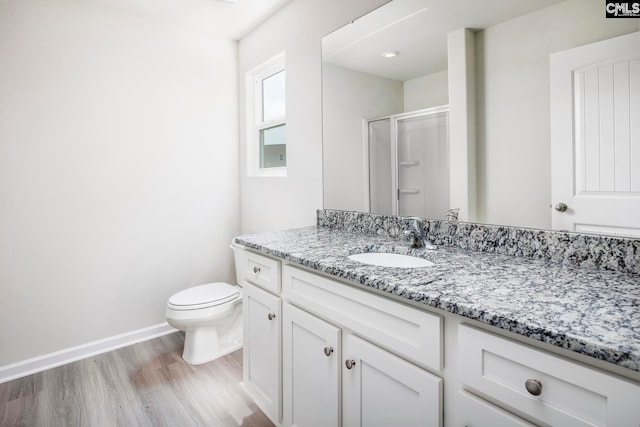 bathroom with vanity, toilet, a shower with door, and hardwood / wood-style floors