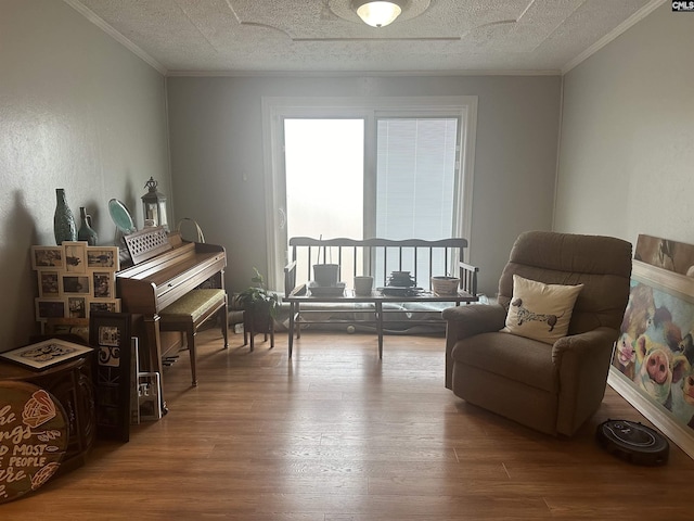 living area with hardwood / wood-style floors, crown molding, and a textured ceiling