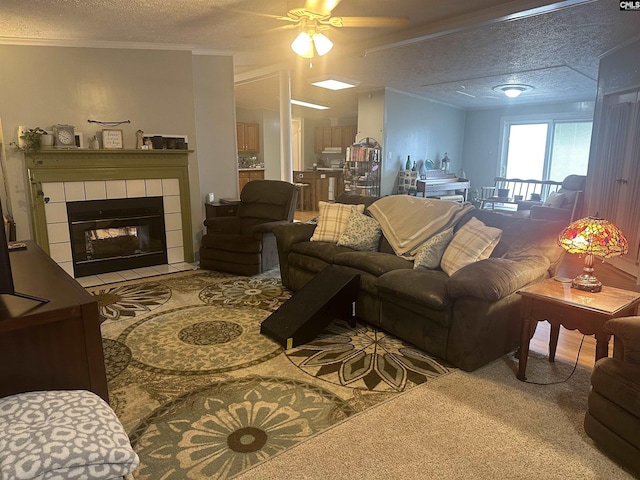 living room featuring crown molding, a tile fireplace, and a textured ceiling