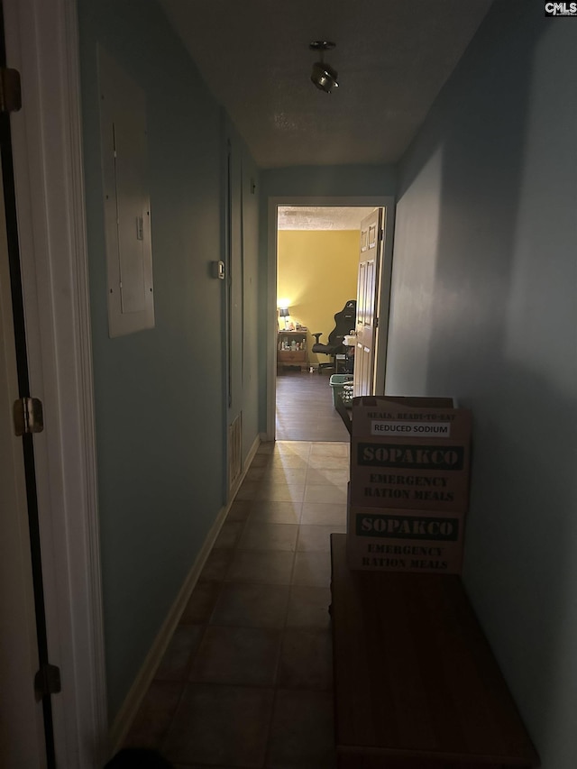 corridor featuring tile patterned flooring and electric panel