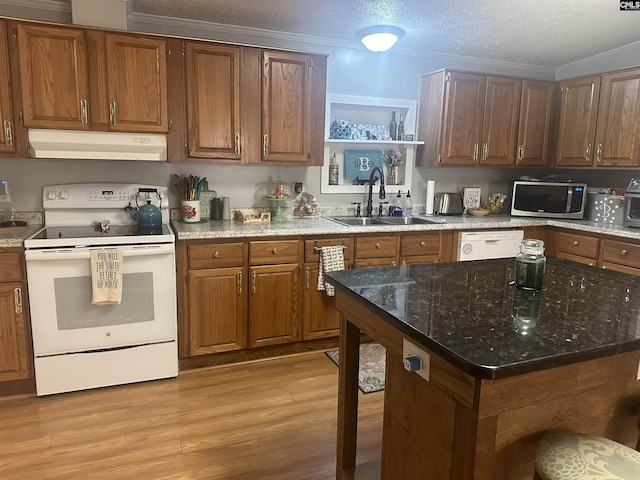 kitchen with sink, a textured ceiling, light wood-type flooring, stone counters, and white appliances