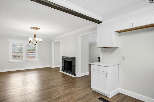 unfurnished living room with crown molding, dark hardwood / wood-style floors, and a notable chandelier