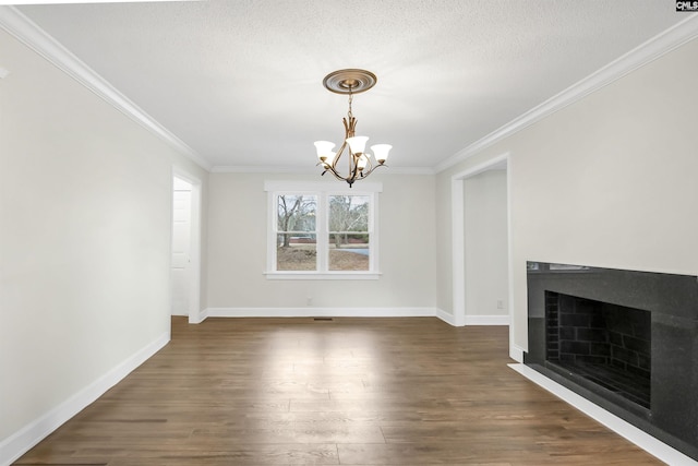 unfurnished living room with crown molding, dark wood-type flooring, a textured ceiling, and a chandelier