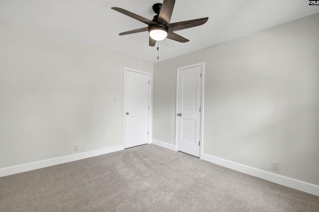 carpeted spare room featuring ceiling fan