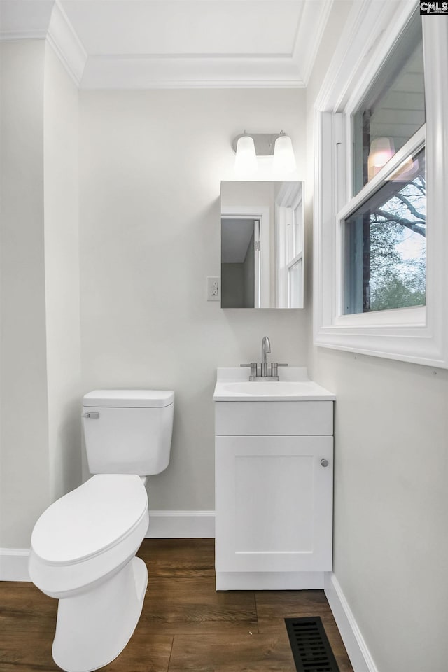 bathroom with crown molding, vanity, hardwood / wood-style flooring, and toilet