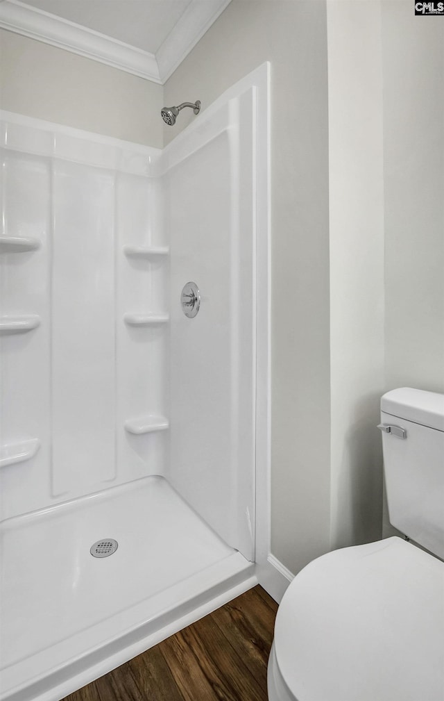 bathroom featuring crown molding, toilet, hardwood / wood-style floors, and walk in shower