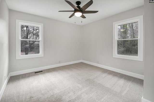 spare room featuring ceiling fan, a healthy amount of sunlight, and carpet flooring