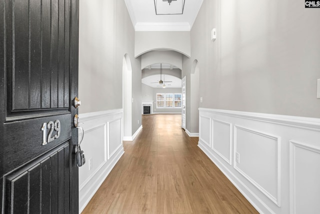 hallway with hardwood / wood-style flooring and ornamental molding