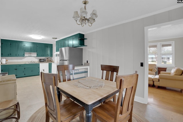 dining room featuring crown molding, sink, and an inviting chandelier