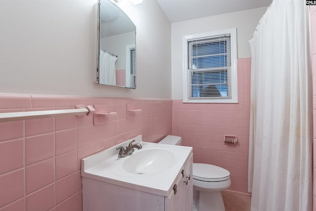 bathroom with tile patterned floors, vanity, toilet, and tile walls