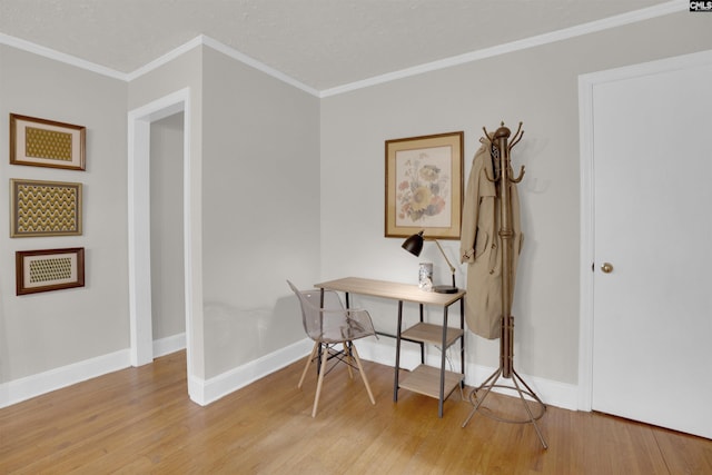 office with ornamental molding, a textured ceiling, and light hardwood / wood-style floors