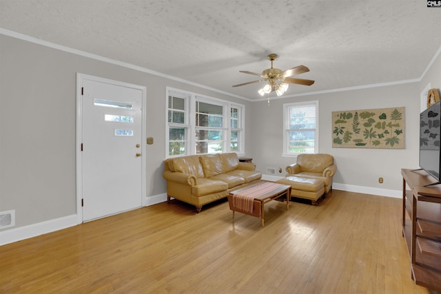 living room featuring crown molding, ceiling fan, a textured ceiling, and light wood-type flooring