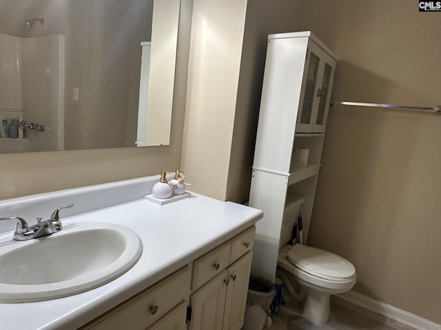 bathroom with walk in shower, vanity, and toilet