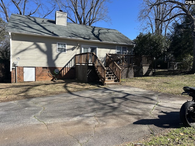 rear view of property featuring a wooden deck