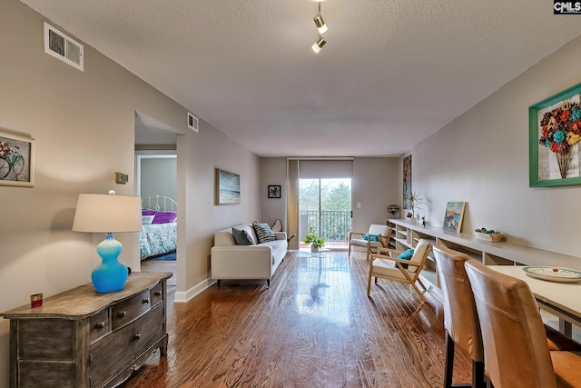 living room featuring wood-type flooring and a textured ceiling