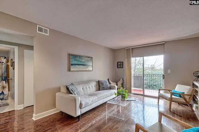 living room featuring a textured ceiling and dark hardwood / wood-style flooring