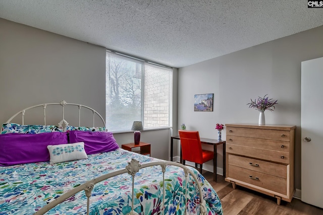 bedroom with dark hardwood / wood-style floors and a textured ceiling