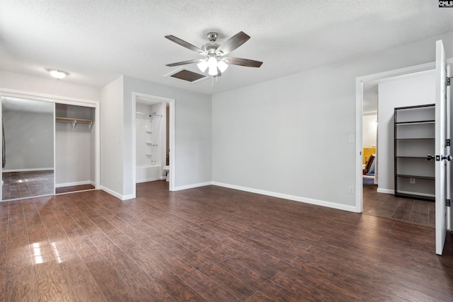 unfurnished bedroom featuring dark wood-type flooring, ceiling fan, a closet, and a textured ceiling