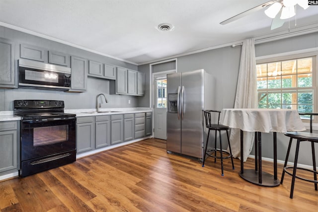 kitchen featuring appliances with stainless steel finishes, sink, and gray cabinetry