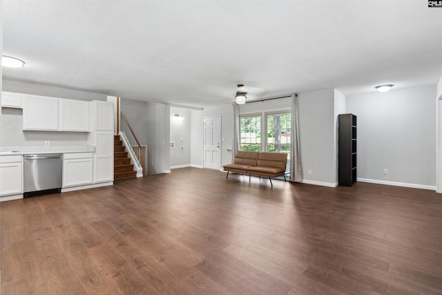 unfurnished living room featuring dark wood-type flooring and a textured ceiling