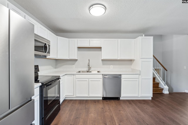 kitchen featuring dark hardwood / wood-style floors, sink, white cabinets, stainless steel appliances, and a textured ceiling