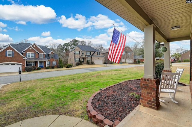 view of yard featuring a garage and covered porch