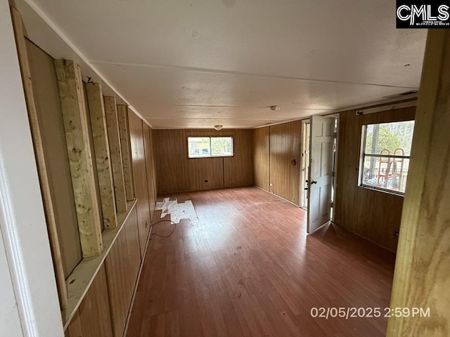 unfurnished room featuring wooden walls and light wood-type flooring